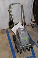 Photo showing the full Earthwise tiller/cultivator with its folded metal handle bars and manual attached.