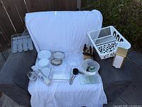 Group shot of all kitchen items on chair including dish rack, plates, rolls, organizer, knife block etc.