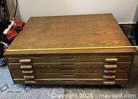 Overall view of wooden flat file cabinet with five drawers and casters