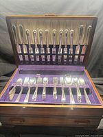 Open chest showing top tray with knives, forks, spoons