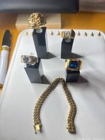 Front view of all four rings on stands and bracelet laid in front