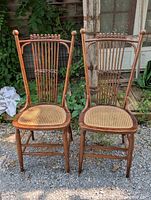 Front view of both Victorian chairs showing spindle backs and cane seats