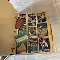 Open binder showing nine baseball cards and loose stats cards