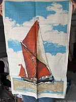 Full view of one tea towel showing sailing barge design and colors