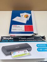Swingline Inspire Plus laminator box and Staples pouch box front view