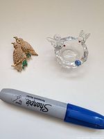 Group shot showing brooch, glass dish and scale reference