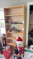 full front view of light wood bookcase with five shelves