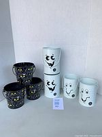 Group shot of all seven pails showing both cat and ghost designs