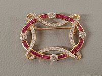 Front view of gold brooch showing rubies and diamonds