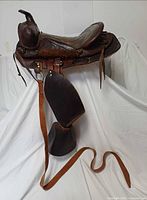 Left side view of complete saddle with straps and stirrups displayed