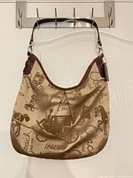 Front view of Coach hobo bag hanging, shows overall style and pattern