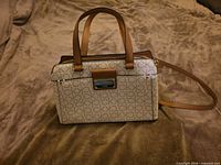 Front view of Calvin Klein monogram satchel with handles and strap