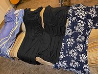 Four dresses laid out on couch showing patterns and colors