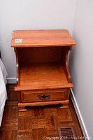 Front view of the Roxton side table showing the drawer closed and the open shelf below the tabletop.
