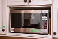 Front view of Panasonic microwave installed in kitchen cabinetry with visible control panel and stainless steel finish.