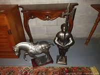Both metal knight and horse figures shown side by side on floor against wall.