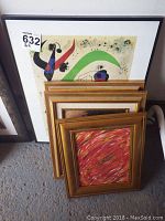 Five framed art pieces stacked together, varying sizes, with prominent large colorful abstract print in back