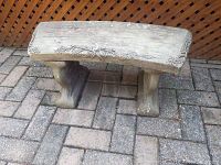 Front view of the curved outdoor garden bench showing floral decorations and the two support legs.
