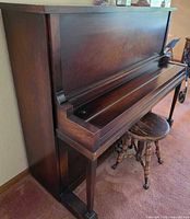 Side and partial front view of upright piano with stool
