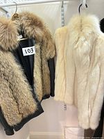 Brown and ivory fur jackets hanging side by side