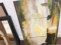 Oil on canvas and framed prints leaning against wall