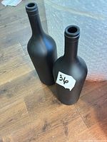 Front view showing both matte black glass bottles