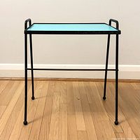 Front angled view of black wrought iron side table with turquoise top