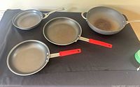 All four nonstick pans: Calphalon, two Tramontina, Heritage wok