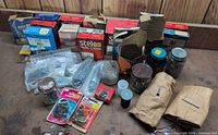 Group shot showing all boxes, jars, bags and envelopes of nails and tacks on workbench