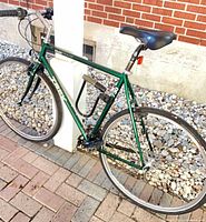 Full view of green Trek Multi-Track 720 bicycle, frame and wheels visible