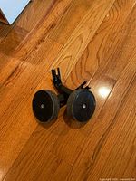 Both training wheels resting tread-to-floor, brackets visible