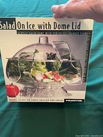 Front of retail box showing acrylic salad bowl with dome lid and servers