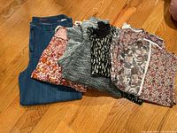 Stack showing blue jeans and four assorted tops
