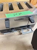 Front view of Hobart toaster showing brand badge, levers, control knobs, crumb tray