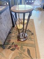 Full view of marble top side table showing tripod base and size relative to surroundings