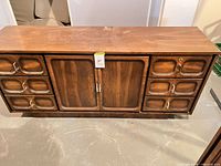 Full frontal view of walnut sideboard showing drawers and cabinet doors