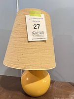 Full view of lamp showing yellow ceramic base and beige shade