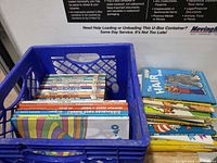 Blue milk crate holding row of Beginner Books spines