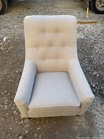 Front view of light gray/beige tufted armchair