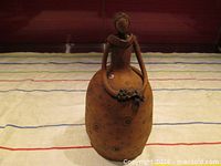 Front view of earthenware lady figurine holding bouquet