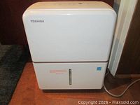 Front view showing Toshiba branding, water-level window and power cord