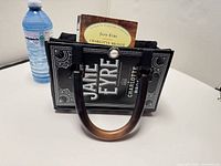Front view showing book cover design "Jane Eyre" and wooden handle