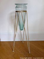 Full view of green glass vase in cream metal stand