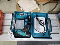 Open carrying case showing drill, charger, manual, bit box, holster