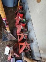 Five red Motomaster jack stands lined along garage floor