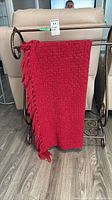 Blanket draped on stand showing overall color, weave and fringe