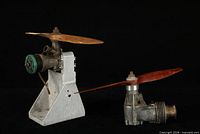 Both vintage model airplane engines side by side, propellers attached