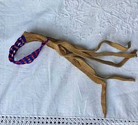Full view of suede leather hair net with beadwork and ties