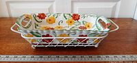 Side view of ceramic baking dish in white wire stand with ruler for scale