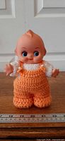Front view of Kewpie doll showing outfit and ruler measurement